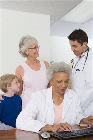 Senior healthcare worker types medical records Stock Photo - Premium Royalty-Free, Code: 694-03332877