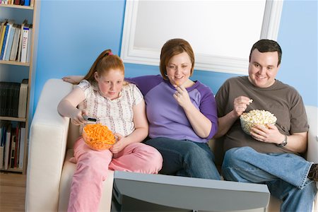 simsearch:696-03399615,k - Overweight family watching television on sofa Stock Photo - Premium Royalty-Free, Code: 694-03363870