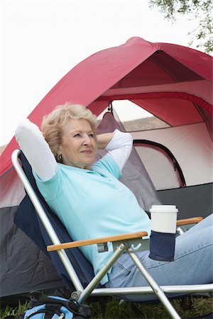senior folding chair - Senior woman sits relaxing outside a tent Stock Photo - Premium Royalty-Free, Code: 694-03440954