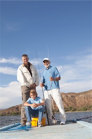 Father, son and grandson sit with fishing equipment on a pier Stock Photo - Premium Royalty-Free, Code: 694-03440951