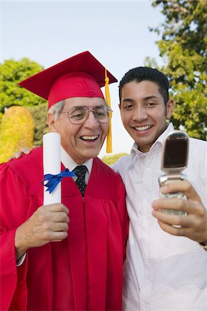 simsearch:693-06014177,k - Senior Graduate and son taking picture with cell phone outside Stock Photo - Premium Royalty-Free, Code: 694-03692635