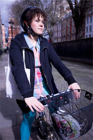 person in a basket of a bike - A female adult riding her bicycle Stock Photo - Premium Royalty-Free, Code: 694-03783306