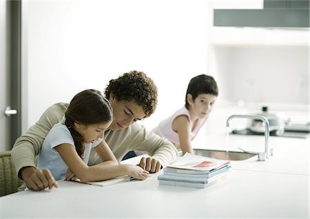 Teenage boy helping younger sister with homework Stock Photo - Premium Royalty-Free, Code: 695-05764309