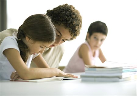 Teenage boy helping younger sister with homework Stock Photo - Premium Royalty-Free, Code: 695-05764310
