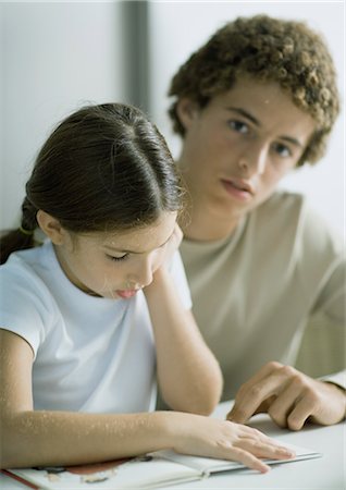 Teenage boy helping younger sister with homework Stock Photo - Premium Royalty-Free, Code: 695-05764311