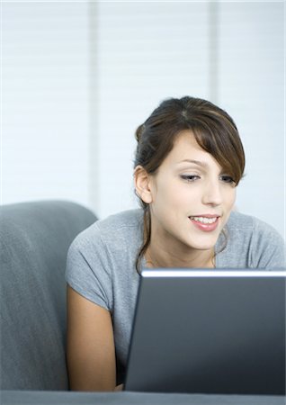 simsearch:695-05771662,k - Young woman on couch, using laptop Stock Photo - Premium Royalty-Free, Code: 695-05764807