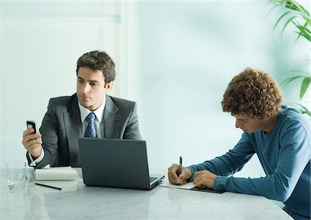 Businessman and intern sitting at table Stock Photo - Premium Royalty-Free, Code: 695-05764832