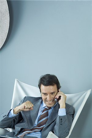 simsearch:695-03376228,k - Businessman using cell phone, making fist, and smiling Stock Photo - Premium Royalty-Free, Code: 695-05765203