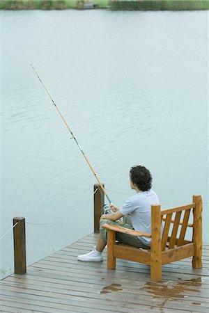 Young man fishing on dock Stock Photo - Premium Royalty-Free, Code: 695-05765539