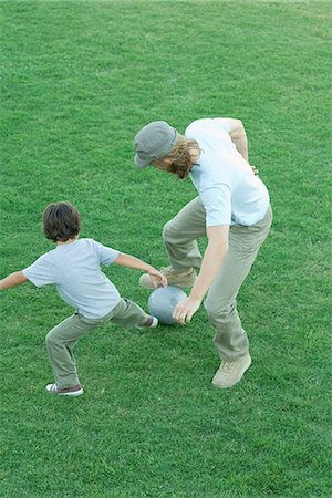 father playing football - Man and boy playing soccer on grass, high angle view, full length Stock Photo - Premium Royalty-Free, Code: 695-05765551