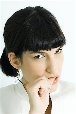 dreading - Woman biting thumb, portrait Stock Photo - Premium Royalty-Free, Code: 695-05765846