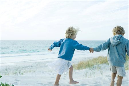 Children holding hands on beach Stock Photo - Premium Royalty-Free, Code: 695-05766074