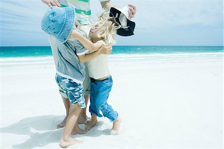 Famille sur la plage, garçon et fille atteinte pour l'autre devant le père Photographie de stock - Premium Libres de Droits, Code: 695-05766154