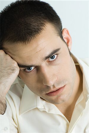 Man holding head, looking at camera, portrait Stock Photo - Premium Royalty-Free, Code: 695-05766182