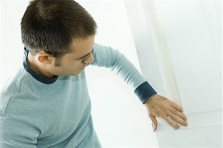 painting tape - Man putting tape on door woodwork in preparation for painting Stock Photo - Premium Royalty-Free, Code: 695-05766292