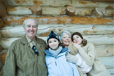 simsearch:696-03401677,k - Senior couple standing with teen and preteen granddaughters in front of log cabin, smiling, portrait Stock Photo - Premium Royalty-Free, Code: 695-05766413