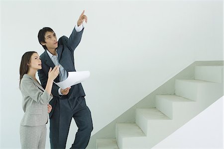 staircase arrow - Well-dressed couple visiting house, man holding blueprint and pointing Stock Photo - Premium Royalty-Free, Code: 695-05766423