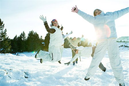 Young friends jumping in the air, dressed in winter clothing, full length Stock Photo - Premium Royalty-Free, Code: 695-05766592