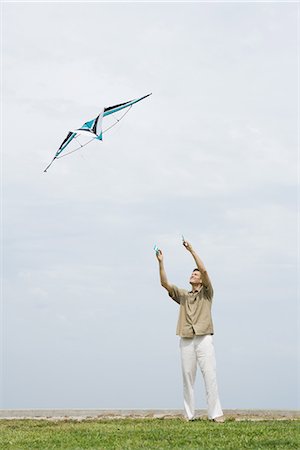 sky in kite alone pic - Man flying kite, arms raised, full length Stock Photo - Premium Royalty-Free, Code: 695-05767211