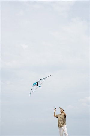 sky in kite alone pic - Man flying kite, looking up Foto de stock - Sin royalties Premium, Código: 695-05767212