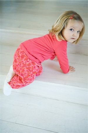 simsearch:632-03027302,k - Blonde toddler girl crawling on steps, looking over shoulder at camera Stock Photo - Premium Royalty-Free, Code: 695-05767364