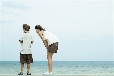 simsearch:614-06043612,k - Brother and sister standing at the beach looking down together, rear view Stock Photo - Premium Royalty-Free, Code: 695-05767417