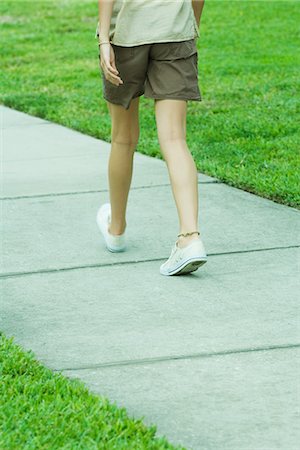 Femme marchant sur le trottoir, taille vers le bas, vue arrière Photographie de stock - Premium Libres de Droits, Code: 695-05767509