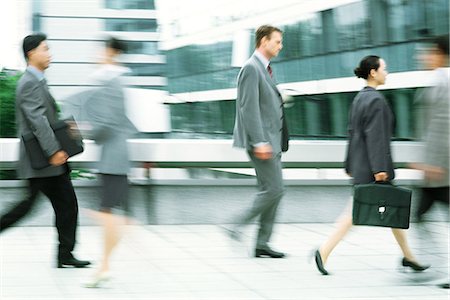 Male and female professionals walking on sidewalk, blurred motion Stock Photo - Premium Royalty-Free, Code: 695-05767731