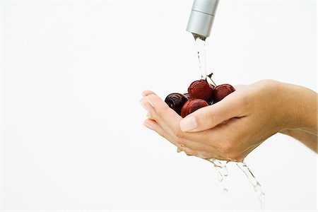 simsearch:632-05816631,k - Woman washing handful of tomatoes under faucet, cropped view of hands, close-up Stock Photo - Premium Royalty-Free, Code: 695-05767771