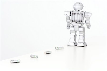 robots - Robot leaving trail of batteries behind it Stock Photo - Premium Royalty-Free, Code: 695-05768058