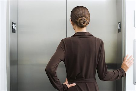 Well-dressed female waiting for elevator, rear view Stock Photo - Premium Royalty-Free, Code: 695-05768133