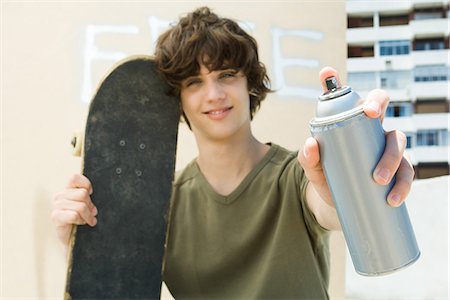 Teen boy holding spray paint can, smiling at camera Stock Photo - Premium Royalty-Free, Code: 695-05768224