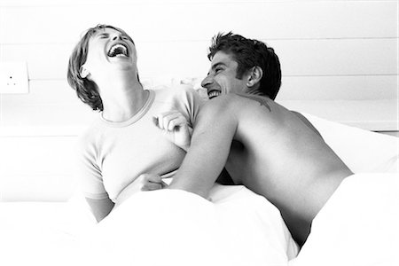 roughhousing - Couple in bed, both laughing Stock Photo - Premium Royalty-Free, Code: 695-05768311