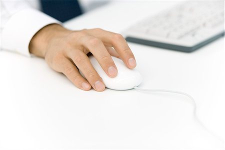 Man using computer mouse, cropped view of hand Stock Photo - Premium Royalty-Free, Code: 695-05768438