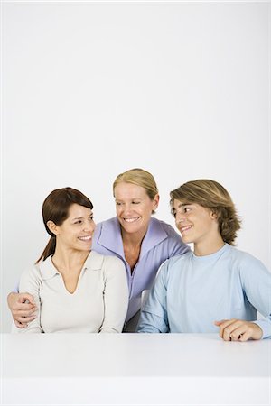 simsearch:695-05769087,k - Mature woman embracing younger woman and teen boy, all smiling, portrait Stock Photo - Premium Royalty-Free, Code: 695-05768847