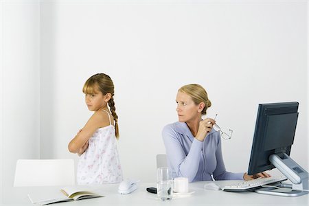 simsearch:695-03380694,k - Woman sitting before computer, looking over shoulder at daughter sulking nearby Stock Photo - Premium Royalty-Free, Code: 695-05768843