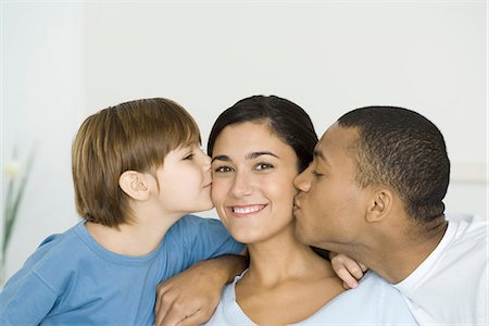 simsearch:632-05816381,k - Husband and son kissing woman's cheeks, woman smiling at camera Stock Photo - Premium Royalty-Free, Code: 695-05768880