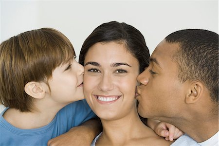 simsearch:632-05816381,k - Husband and son kissing woman's cheeks, woman smiling at camera Stock Photo - Premium Royalty-Free, Code: 695-05768881