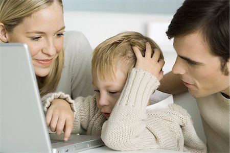 Parents helping little boy use laptop computer, close-up Foto de stock - Sin royalties Premium, Código: 695-05768883
