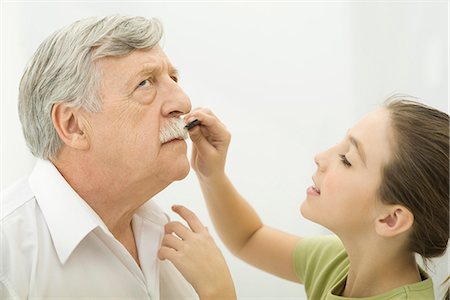 preteen girls looking older - Grandfather patiently allowing granddaughter to groom his mustache, side view Stock Photo - Premium Royalty-Free, Code: 695-05769039
