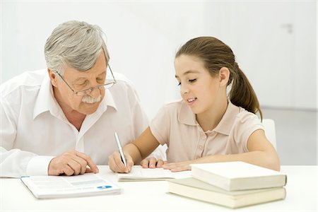 preteen girls looking older - Grandfather helping granddaughter with homework Stock Photo - Premium Royalty-Free, Code: 695-05769043