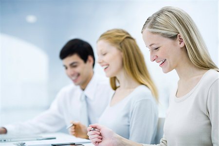 productivity - Three colleagues working at desk, smiling Stock Photo - Premium Royalty-Free, Code: 695-05769051
