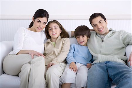 simsearch:695-05769087,k - Family sitting together on sofa, smiling at camera, portrait Stock Photo - Premium Royalty-Free, Code: 695-05769080