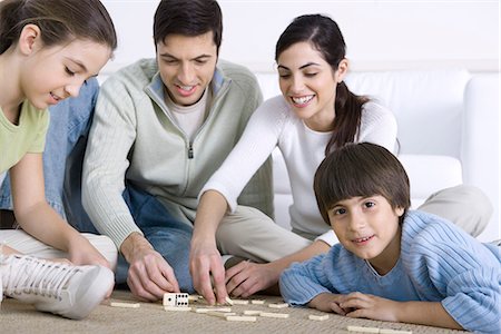 simsearch:695-05769087,k - Family seated on floor playing dominoes together, boy smiling at camera Stock Photo - Premium Royalty-Free, Code: 695-05769090