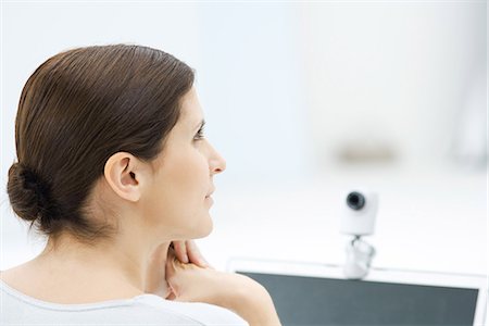 Woman sitting in front of webcam, looking away, rear view Stock Photo - Premium Royalty-Free, Code: 695-05769147
