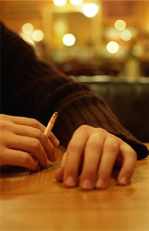 Hand holding lit cigarette Stock Photo - Premium Royalty-Free, Code: 695-05769379