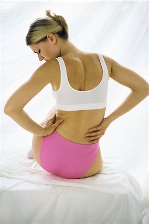 Woman in underwear, holding lower back Foto de stock - Sin royalties Premium, Código: 695-05769615