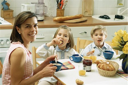 family eating cereal - Famille assis à table pour le petit déjeuner, souriant à la caméra Photographie de stock - Premium Libres de Droits, Code: 695-05769675