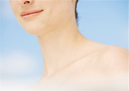 Woman's lower face and shoulder, sky in background Stock Photo - Premium Royalty-Free, Code: 695-05762288