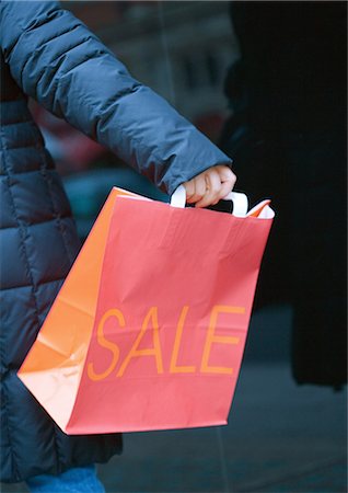 reduction - Person holding out shopping bag with "sale" printed on side Stock Photo - Premium Royalty-Free, Code: 695-05762966